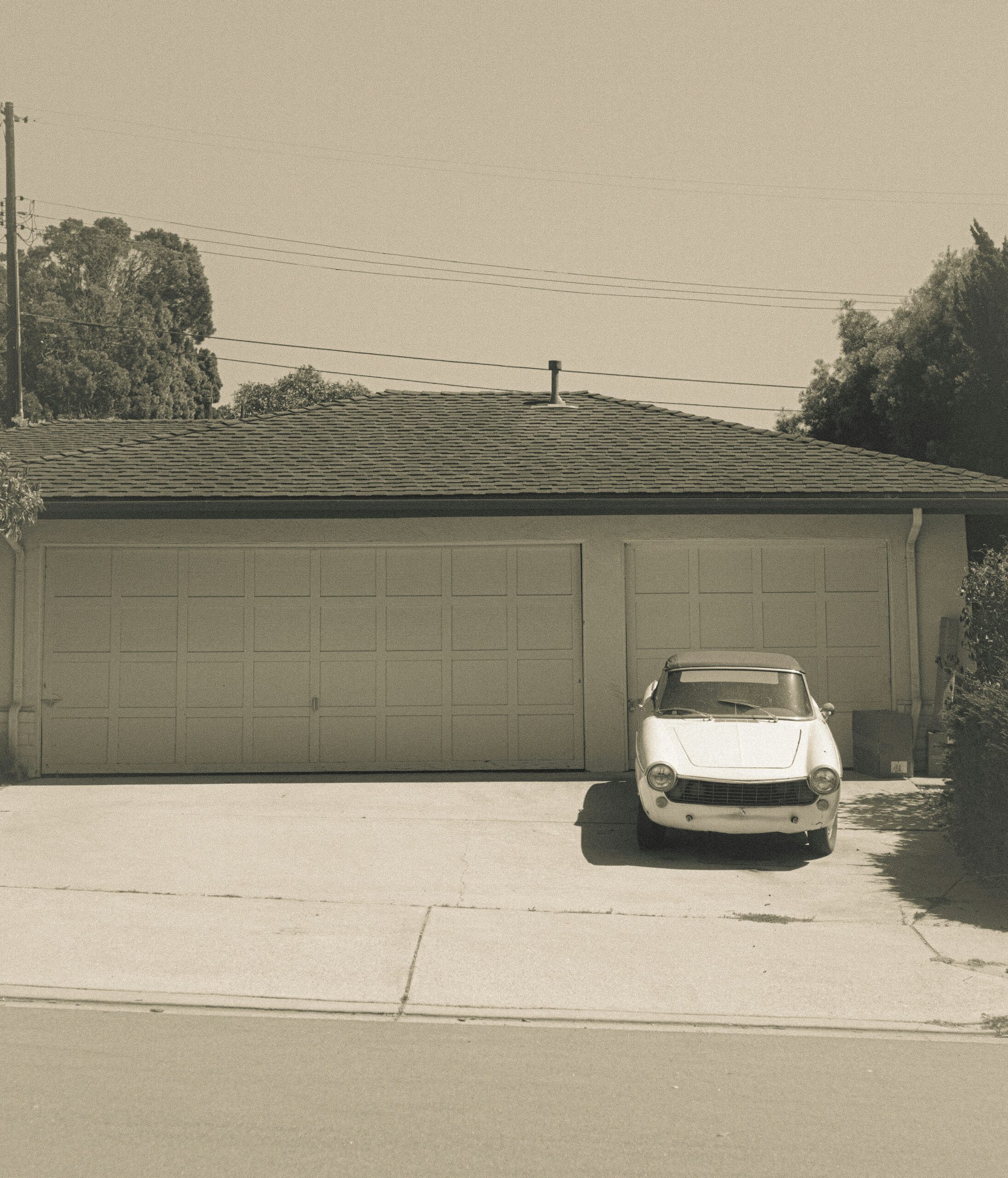 white car parked beside brown brick wall